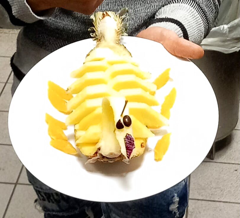 Ananas intagliato a forma di pesce, dessert della casa